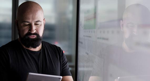 Man looking at tablet with data reflected